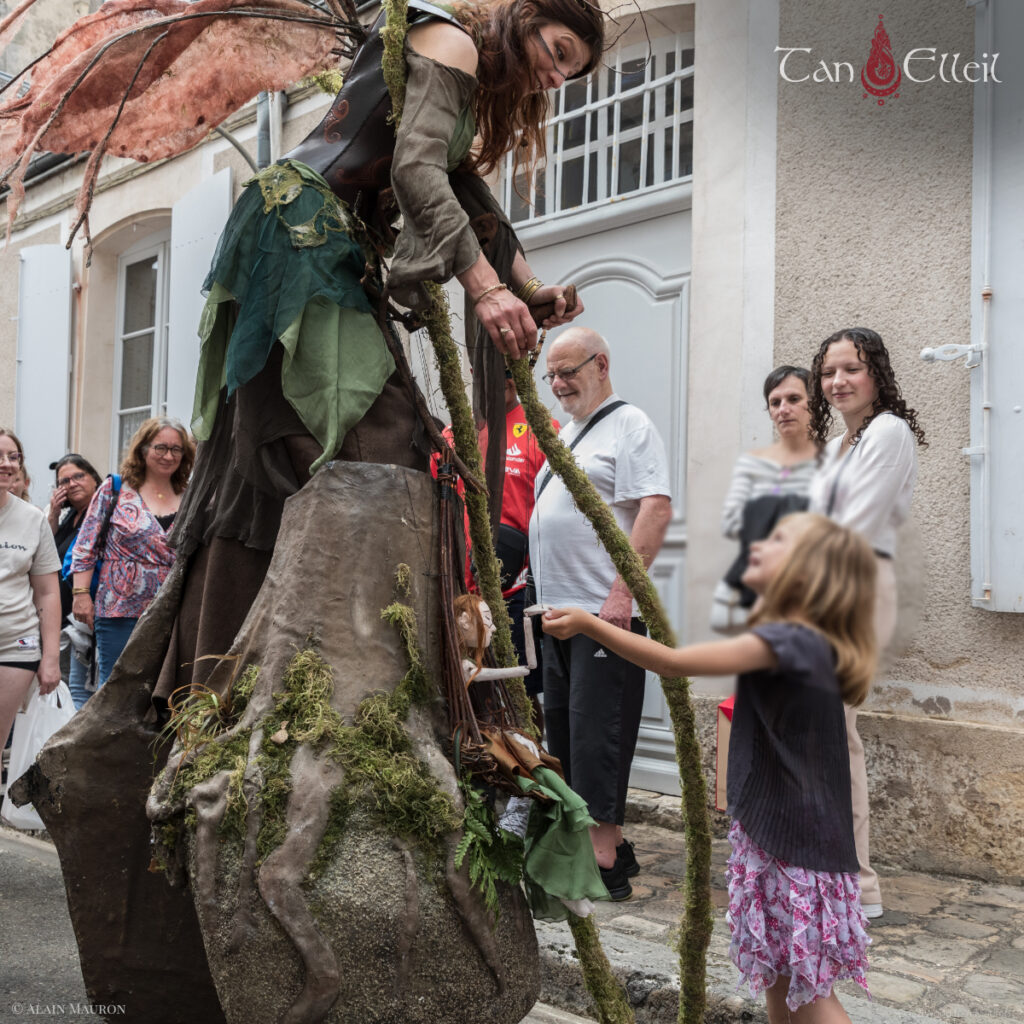 tan-elleil-contes-du-bois-den-haut-deambulation-musicale-bretagne-marionnette-echasses6 Interaction entre les enfants et la marionnette lors de la déambulation musicale bretonne avec échassier et marionnette
