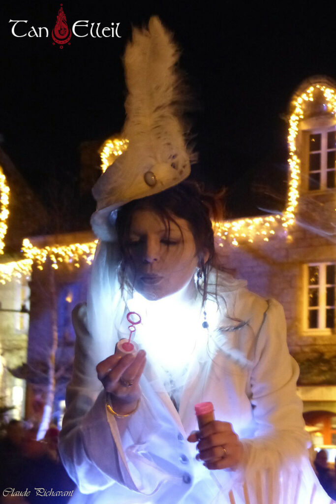 Jeu de bulles avec les enfants de la déambulation musicale avec échassiers blanc lumineux