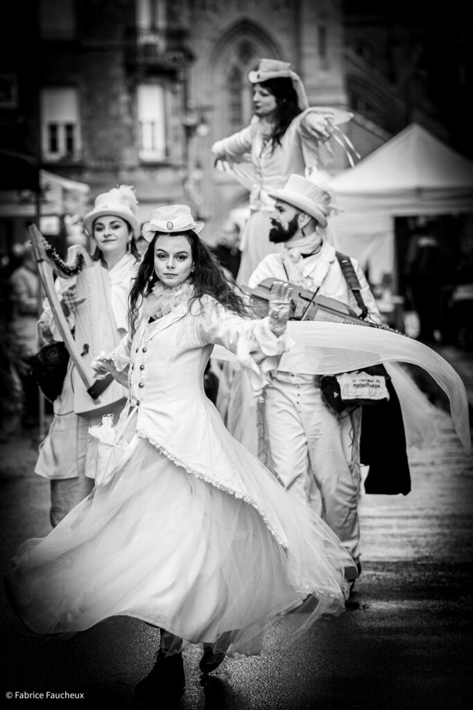 La danse de la déambulation musicale avec échassiers blanc lumineux